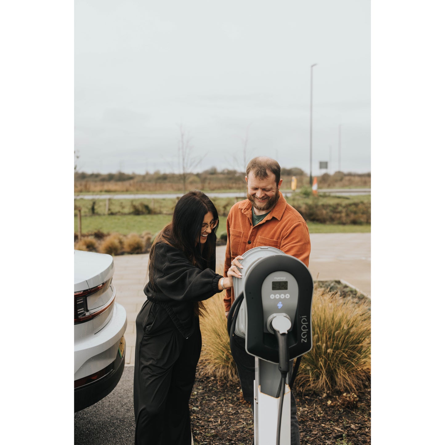 zappi Tethered EV Charger in Black - two people using