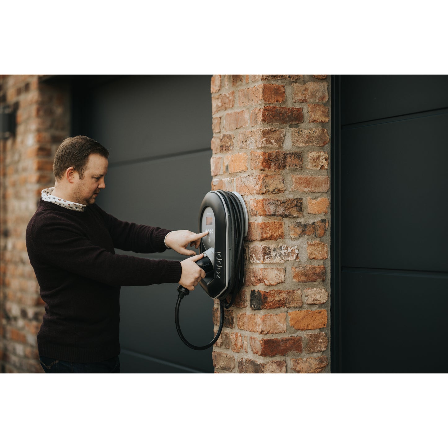 zappi Tethered EV Charger in Black - man pressing button